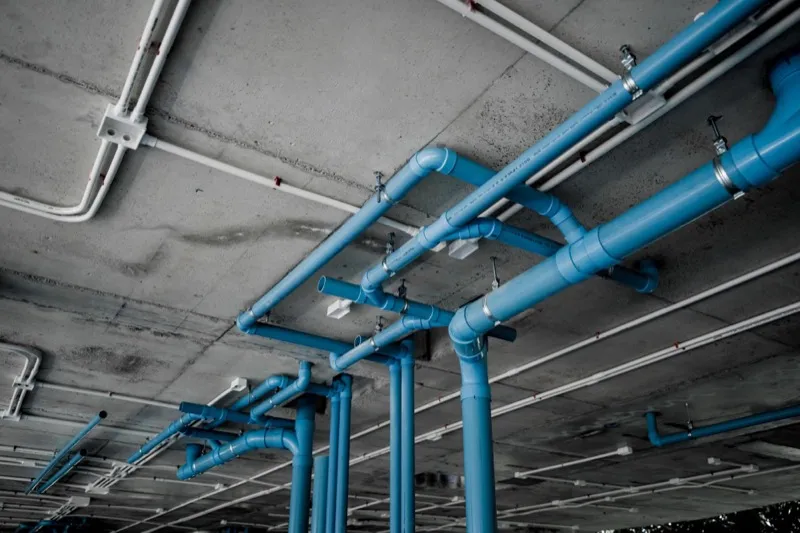 Run of copper water supply pipes strapped along a ceiling